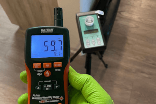 Mold inspector using moisture meter and air sampling equipment in a US home